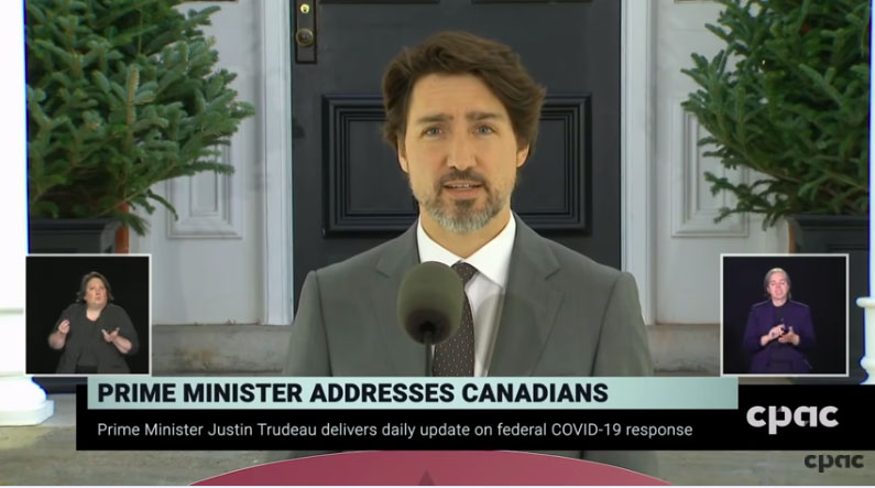 Le Premier ministre Trudeau s'adressant aux Canadiens avec des interprètes en langue des signes en bas à gauche et à droite de l'écran.